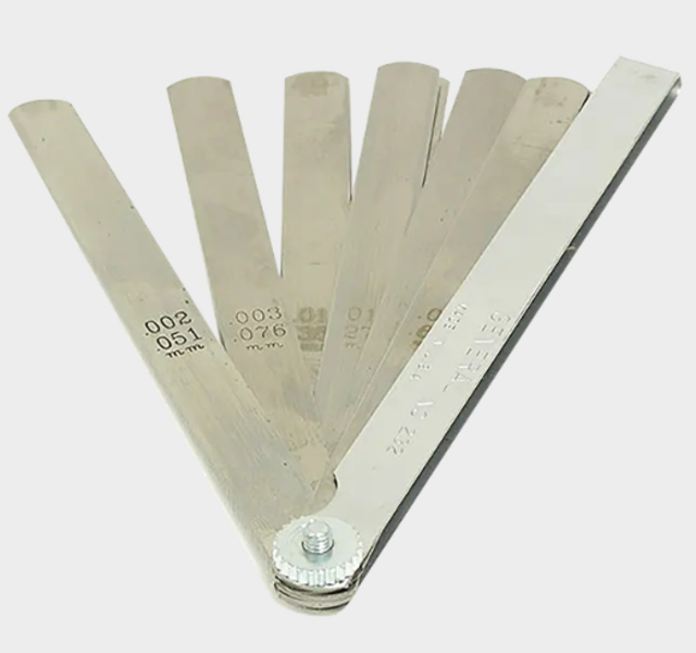 Feeler gauges are used for precise alignment of the base and platen.